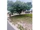 Exterior view of a home featuring a large tree in the yard, offering shade and curb appeal at 72 Lake Shore Dr, Palm Harbor, FL 34684