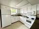 Kitchen featuring white appliances, white cabinets and tile flooring at 72 Lake Shore Dr, Palm Harbor, FL 34684