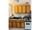Kitchen with wood cabinets, white appliances, and a tile backsplash at 72 Lake Shore Dr, Palm Harbor, FL 34684