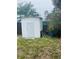 White shed in the backyard with a secure door, great for storage at 72 Lake Shore Dr, Palm Harbor, FL 34684