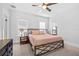 Comfortable bedroom with a metal frame bed, ceiling fan, natural light, and neutral color scheme at 910 E Chelsea St, Tampa, FL 33603