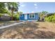 Beautiful blue home with manicured lawn, creating a welcoming curb appeal at 910 E Chelsea St, Tampa, FL 33603