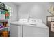 Laundry room with modern white washer and dryer and storage at 910 E Chelsea St, Tampa, FL 33603