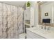 Bathroom with a vanity, marble shower curtain, white cabinet, and a decorative mirror at 9322 Via Segovia, New Port Richey, FL 34655