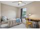 Comfortable bedroom with a ceiling fan, window, and a desk with a stylish wicker chair at 9322 Via Segovia, New Port Richey, FL 34655