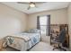 Neutral bedroom featuring a ceiling fan, window, and a wood desk with shelving at 9322 Via Segovia, New Port Richey, FL 34655
