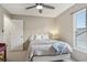 Well-lit bedroom featuring a ceiling fan, window and a decorative lamp at 9322 Via Segovia, New Port Richey, FL 34655