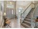 Elegant foyer with high ceilings, tile flooring, decorative lighting, staircase access, and a view of the dining room at 9322 Via Segovia, New Port Richey, FL 34655