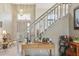 Well-lit foyer featuring staircase access, decorative lighting, neutral walls, and adjacent office desk at 9322 Via Segovia, New Port Richey, FL 34655