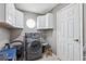 The laundry room featuring a washer, dryer, and ample storage space at 9322 Via Segovia, New Port Richey, FL 34655