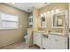 Bathroom featuring double sinks, a window for natural light, and white cabinets at 9322 Via Segovia, New Port Richey, FL 34655