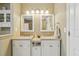 A well-lit main bathroom featuring double sinks, granite countertops, and white cabinetry at 9322 Via Segovia, New Port Richey, FL 34655