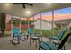 Inviting screened patio with rocking chairs, tables, and a beautiful sunset view at 9322 Via Segovia, New Port Richey, FL 34655