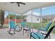 Relaxing screened patio with rocking chairs, tables, and views of the backyard at 9322 Via Segovia, New Port Richey, FL 34655