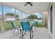 Bright screened patio featuring rocking chairs, tables, and an outdoor view at 9322 Via Segovia, New Port Richey, FL 34655