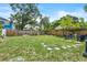 Large fenced backyard with lush grass, stone pavers, and seating area at 1006 E 23Rd Ave, Tampa, FL 33605