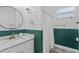 Charming bathroom featuring a modern vanity, round mirror, decorative floor tiles, and a shower with curtain at 1006 E 23Rd Ave, Tampa, FL 33605