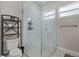 Modern bathroom with glass-enclosed shower, white subway tile, and stylish fixtures and a storage rack at 1006 E 23Rd Ave, Tampa, FL 33605