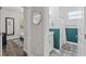 Stylish bathroom with modern vanity, round mirror, and decorative floor tiles, leading to a comfortable bedroom at 1006 E 23Rd Ave, Tampa, FL 33605
