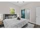 Cozy bedroom features a comfortable queen bed, ensuite bathroom with sliding door and a bright window at 1006 E 23Rd Ave, Tampa, FL 33605