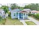 Charming home exterior with a blue door, lovely landscaping, and inviting curb appeal at 1006 E 23Rd Ave, Tampa, FL 33605