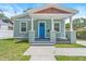 Charming single-story home featuring a quaint front porch, a blue front door, and well-maintained landscaping at 1006 E 23Rd Ave, Tampa, FL 33605