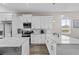Modern kitchen featuring white cabinets, stainless steel appliances, and a large center island with marble countertops at 1006 E 23Rd Ave, Tampa, FL 33605