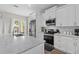 Well-equipped kitchen features stainless steel appliances, white cabinetry, marble countertops, and ample counter space at 1006 E 23Rd Ave, Tampa, FL 33605