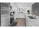 Open concept kitchen boasts white cabinetry, stainless steel appliances, and marble countertops, perfect for entertaining at 1006 E 23Rd Ave, Tampa, FL 33605
