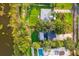 Aerial view showcasing a home with a green lawn, mature trees, and a swimming pool near the waterfront at 1045 28Th S Ave, St Petersburg, FL 33705
