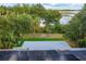 A view from a solar panel rooftop onto a backyard with trees and a lake beyond a fence at 1045 28Th S Ave, St Petersburg, FL 33705