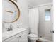 Bathroom features a round mirror above a white vanity and a shower with a white curtain and tiled walls at 1045 28Th S Ave, St Petersburg, FL 33705