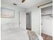 Bedroom features tile floors, blue walls, a ceiling fan, and a closet with a white door in a bright home at 1045 28Th S Ave, St Petersburg, FL 33705