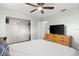 Bedroom with tile floors and blue walls features a ceiling fan, a large closet, and a TV on a dresser at 1045 28Th S Ave, St Petersburg, FL 33705