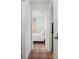 View of a bedroom with a simple bed and white linen, showing the entrance hall with terracotta floors at 1045 28Th S Ave, St Petersburg, FL 33705
