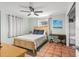 Bright bedroom with light blue walls, tile floors, a ceiling fan, a wooden bed, and a small desk at 1045 28Th S Ave, St Petersburg, FL 33705