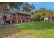 Exterior view of the home featuring a screened deck, lush lawn and mature trees at 1045 28Th S Ave, St Petersburg, FL 33705