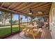 Inviting screened porch with wood ceiling, ceiling fan, and a picnic table with a tranquil backyard and lake view at 1045 28Th S Ave, St Petersburg, FL 33705