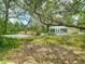 Spacious backyard with pool, grassy lawn, and mature trees offering shade and privacy at 10930 Marjory Ave, Tampa, FL 33612