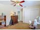 Neutral bedroom with ceiling fan, sewing desk, dresser, and closet at 10930 Marjory Ave, Tampa, FL 33612