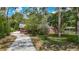 Charming brick home featuring a long driveway, mature trees, and a well-maintained lawn at 10930 Marjory Ave, Tampa, FL 33612