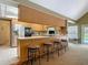 Open kitchen with bar seating, stainless steel appliances, and a view of the vaulted ceiling at 10930 Marjory Ave, Tampa, FL 33612