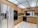 Well-equipped kitchen with wooden cabinets, tiled floors, and stainless steel refrigerator at 10930 Marjory Ave, Tampa, FL 33612