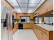 Functional kitchen featuring wooden cabinets, tile floors, and stainless steel refrigerator at 10930 Marjory Ave, Tampa, FL 33612