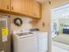 Laundry room features a Samsung washer/dryer, water heater, and wooden cabinets; access to bonus room at 10930 Marjory Ave, Tampa, FL 33612