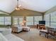 Cozy living room featuring vaulted ceilings, a plush sofa, and natural light streaming through large windows at 10930 Marjory Ave, Tampa, FL 33612