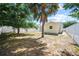 The backyard features a lawn and some trees, enclosed with white privacy fencing at 11363 Cocoa Beach Dr, Riverview, FL 33569
