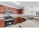 Well-lit kitchen featuring stainless steel appliances, wood cabinets, and light countertops at 11615 Mango Ridge Blvd # 39, Seffner, FL 33584