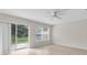 A sunlit living room with tile floors, a ceiling fan, and a sliding glass door to the outside at 11615 Mango Ridge Blvd # 39, Seffner, FL 33584