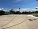 Outdoor community basketball court with a net, fencing, and lighting on a partly cloudy day at 12032 Grand Kempston Dr, Gibsonton, FL 33534